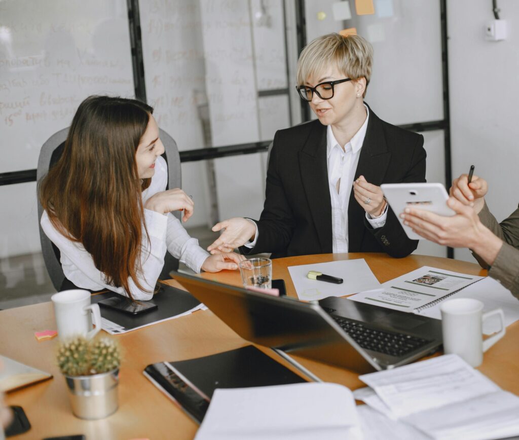 Group of business professionals engaged in a meeting discussing strategies and cooperation.